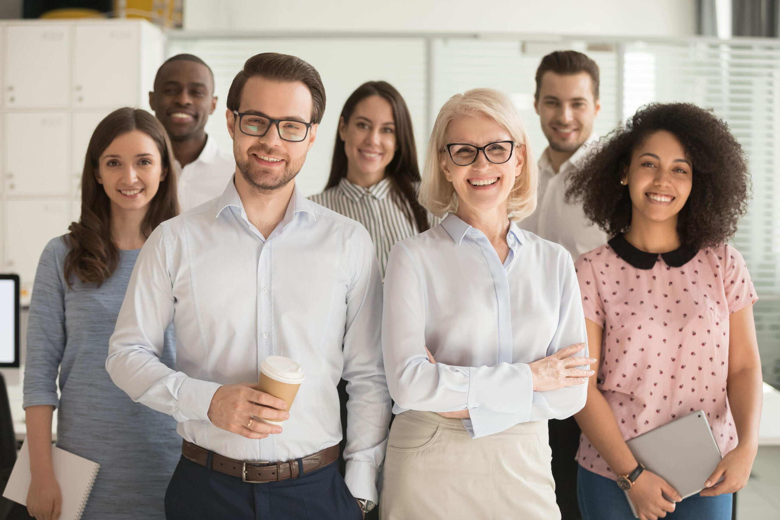 Smiling professional business coaches leaders mentors posing together with diverse office workers interns group, happy multicultural staff corporate employees people looking at camera, team portrait